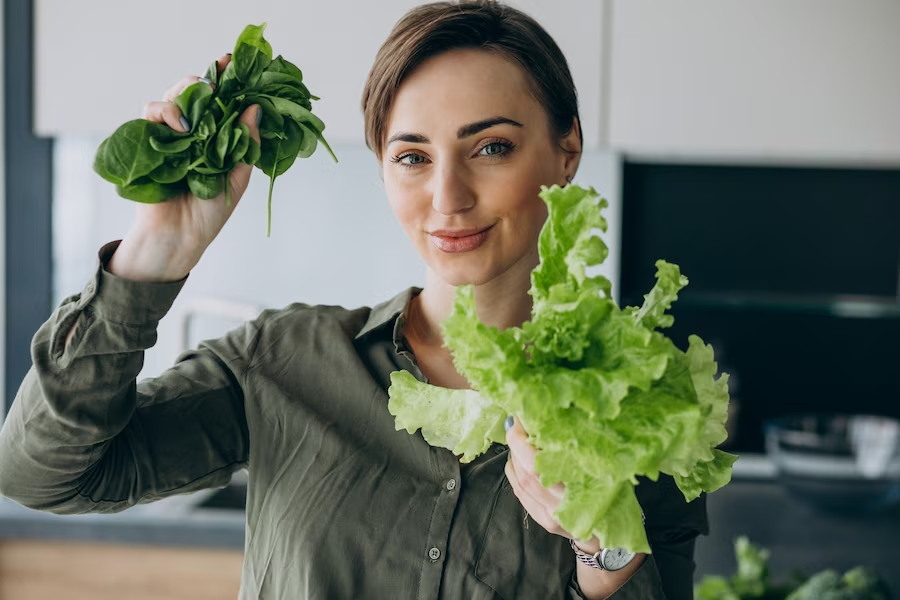 Woman holding green leafy vegetables