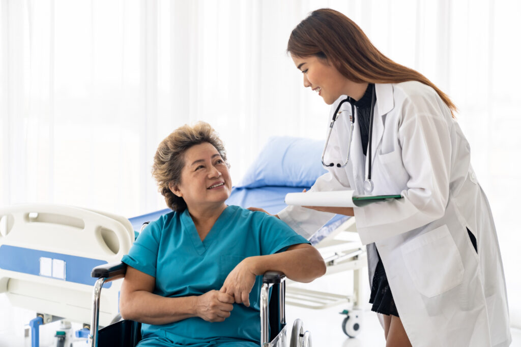 Healthcare professional talking with a patient sitting in a wheelchair